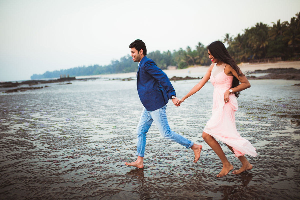couple running away in blue and pink dress